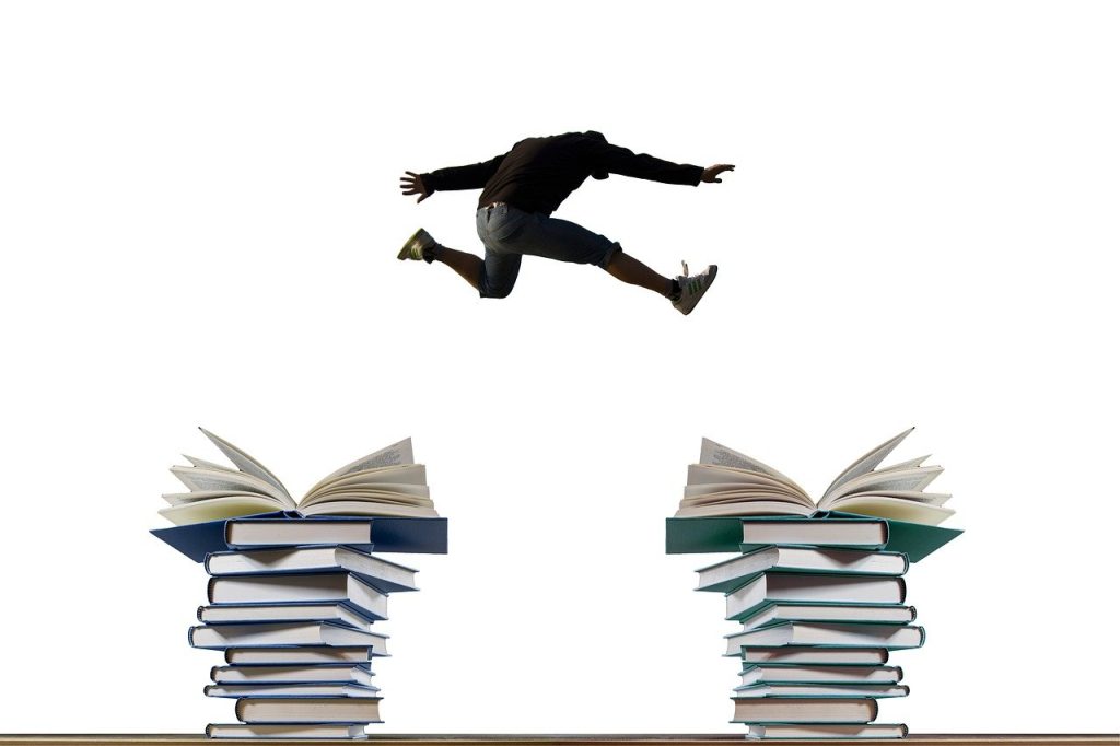 Student springt van de ene stapel boeken naar de andere stapel