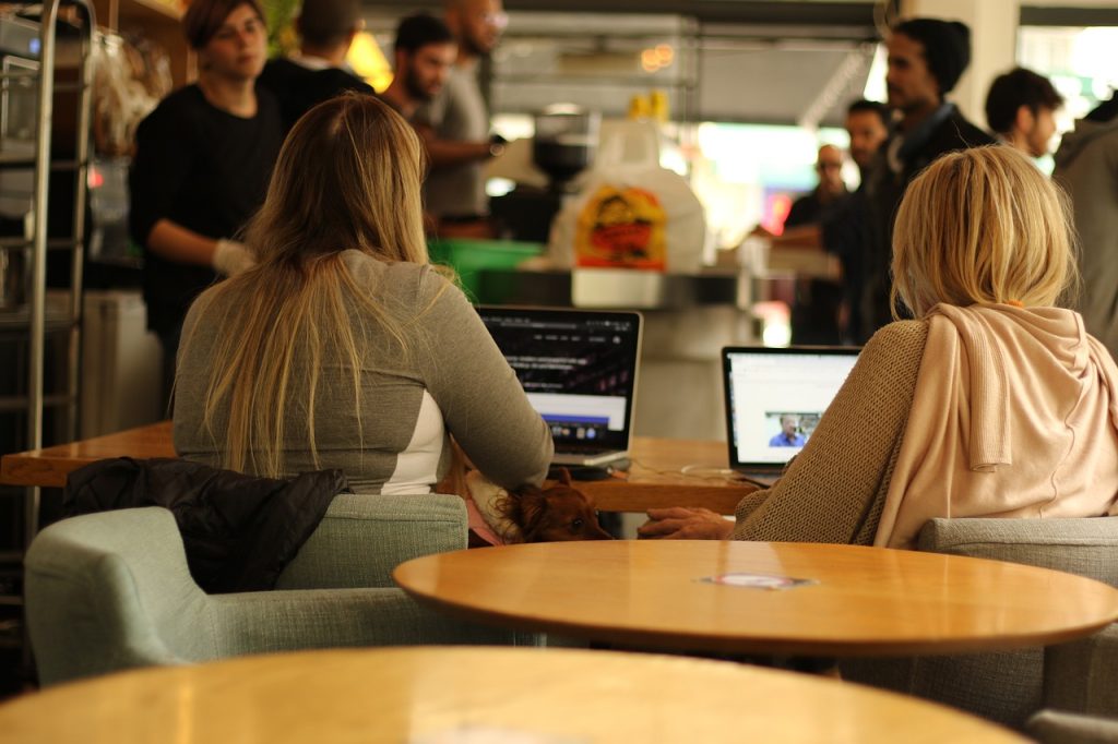 dames op rug achter laptop en daarachter informele borrel