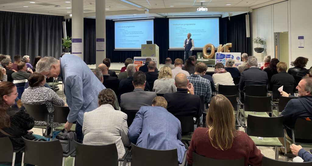 blik vanachter de zaal naar podium tijdens NED Conferentie