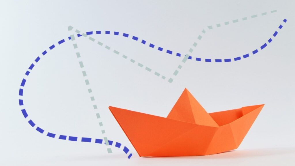 oranje origami bootje met op de achtergrond twee routes om van a naar b te komen.