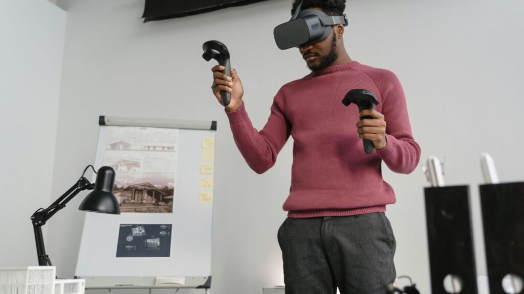 man met VR bril op gezicht staat voor z'n bureau