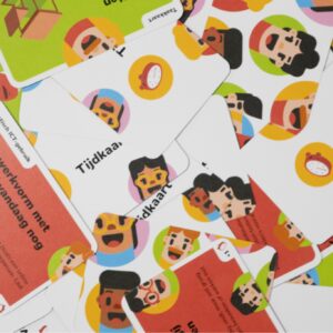 leurrijke pelkaarten van het spel Digidoen op tafel kriskras door en over elkaar