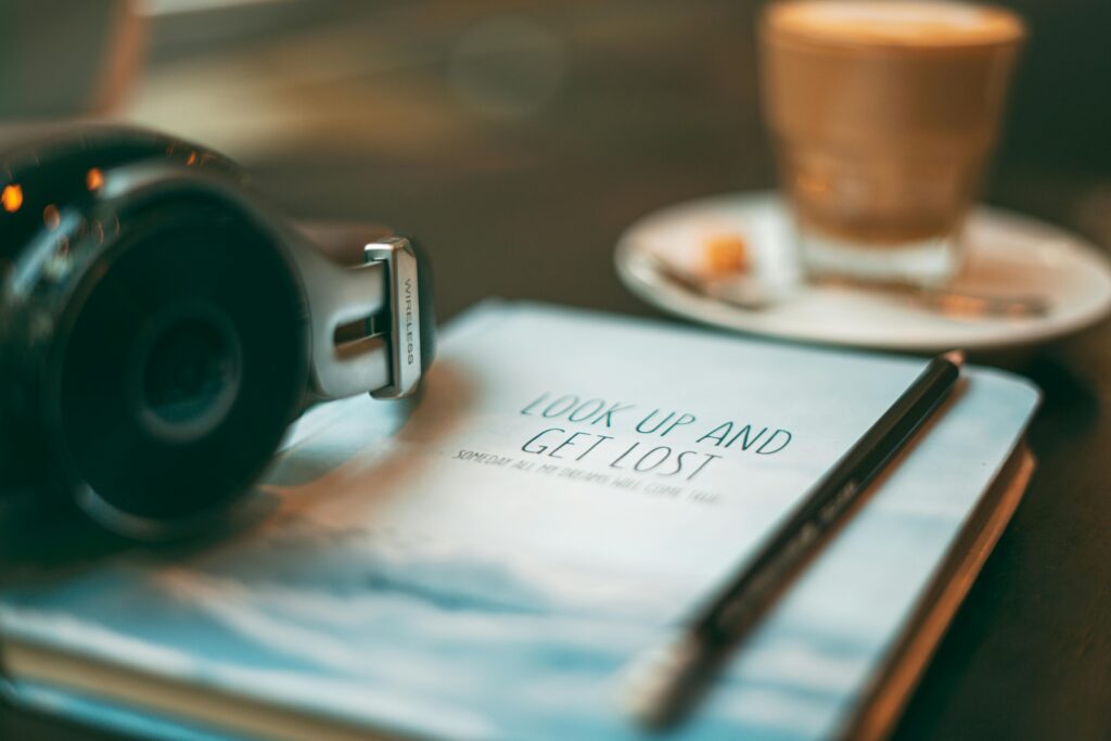 sfeerbeeld koffie, koptelefoon, boek