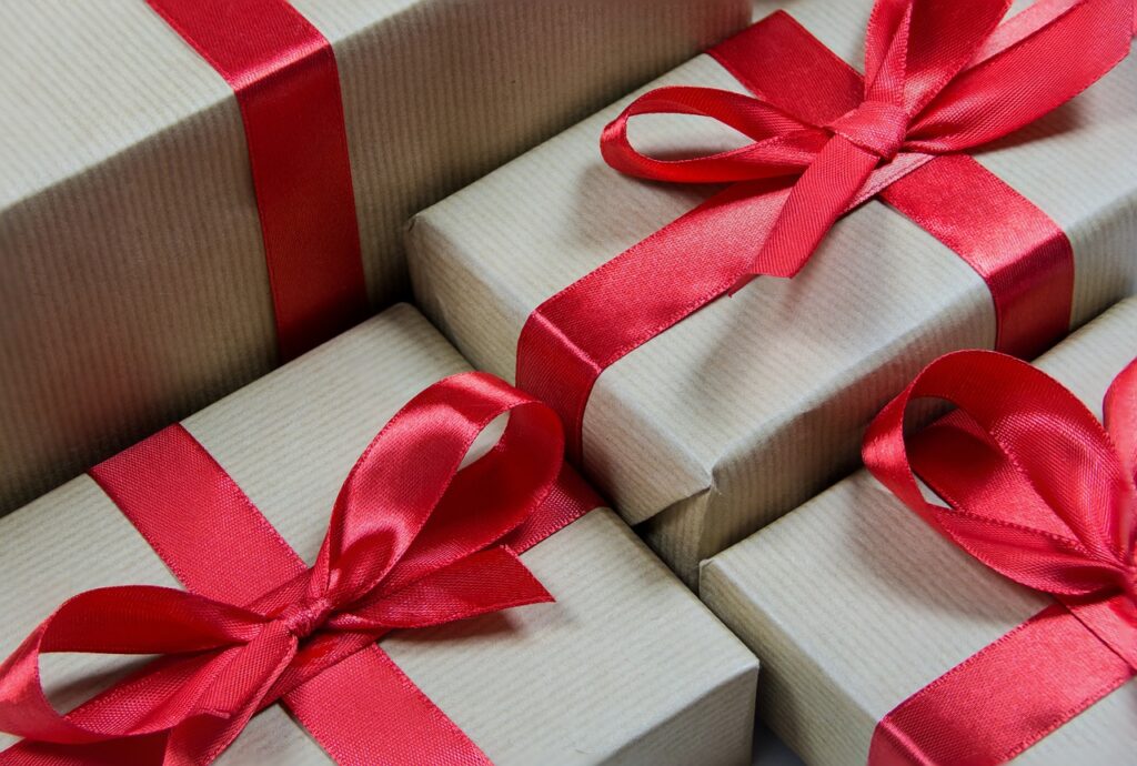 4 cadeautjes in brownpaper met rode strikjes erom