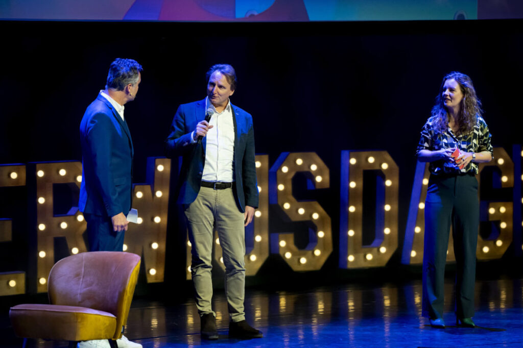 afbeelding van drie mensen op het podium van de SURF onderwijsdagen in 2024 bij Amare in Den Haag