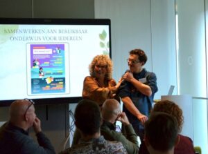 Student en docent van het VISTA college laten hun poster - Wie betaalt wat - zien 